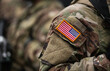 © Dragoș Asaftei - US Army soldiers uniform. Close up photo with the United States of America flag on a military soldier uniform with the gun next to it. Military industry detail concept photo.