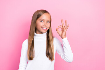 Wall Mural - Photo of satisfied girl wear stylish sweater hand demonstrate positive feedback okey symbol empty space isolated on pink color background