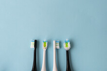 Modern Electric Toothbrush On A Blue Background, It's Time To Change The Brush - Old And New Brush Attachment. Hygiene Concept For Daily Oral Care.