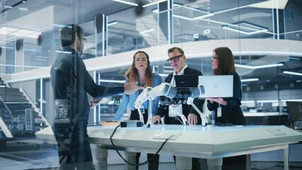 Fototapete - Chief Robotics Engineer Having Meeting with Project Manager and Machinery Operators Next to a Mobile Robot Animal Project. Young Team Using Computers, Discussing the Development of an AI Robotic Dog.