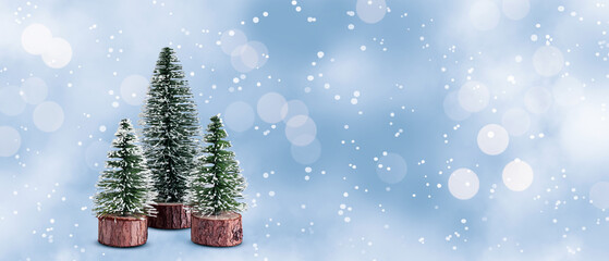 Wall Mural - Mini Christmas trees on snow design background.