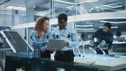 Fototapete - Portrait of Two Multiethnic Female and Male Engineers Use Laptop Computer to Connect, Analyze and Discuss How to Program a Robot Dog. Standing in High Tech Research Laboratory with Modern Equipment.