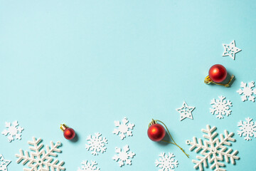 Christmas composition with white and red holiday decorations on blue background. Top view with copy space.