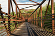 bike trail and a long footbridge over a river with distant cyclist - Poudre River Trail in Fort Collins, Colorado