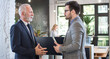 © Bojan - Young and old businessmen in formal suits on a meeting in office.