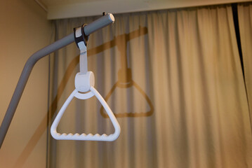 Device for lifting from a hospital bed. Brown curtains in the room