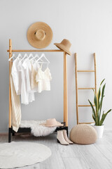 Wall Mural - Interior of light dressing room with rack, clothes and ladder