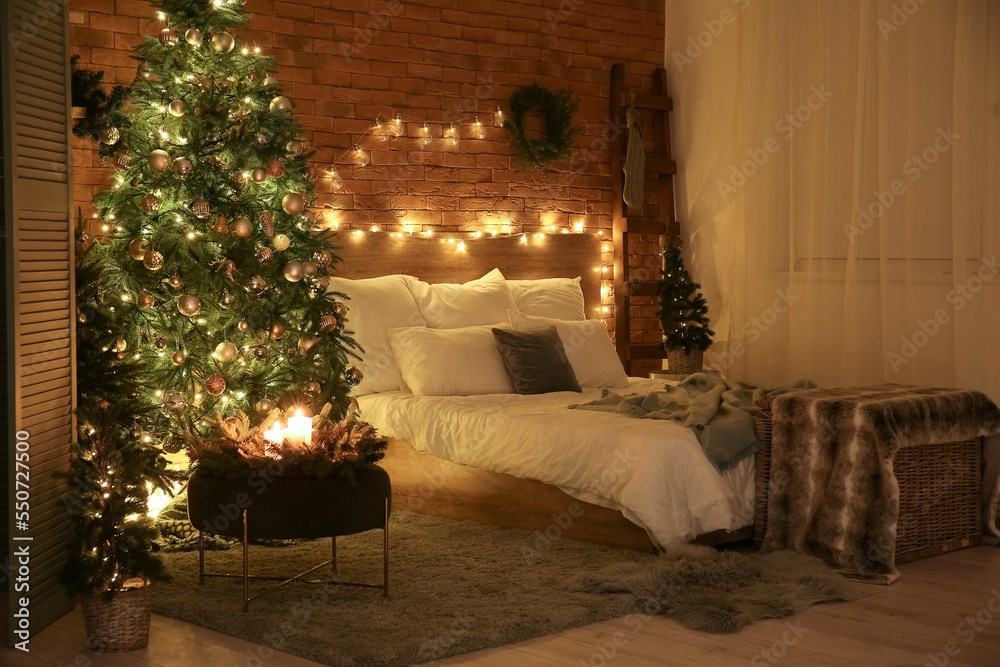 Interior of dark bedroom with Christmas trees and glowing lights