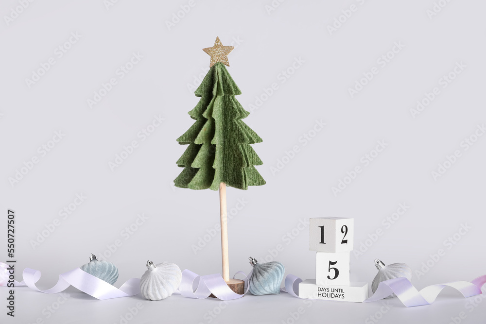 Composition with felt Christmas tree, decorations, cube calendar and ribbon on white background