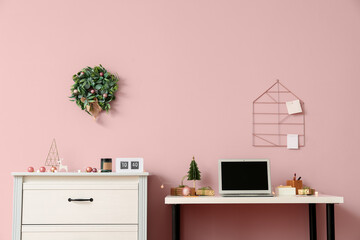 Canvas Print - Workplace with laptop and Christmas gifts near pink wall in office