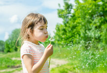 Cute Girl Blowing Dandelion Seed