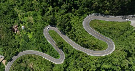 Wall Mural - aerial view ROAD No.1081 beautiful curve winding mountain road between Pua District,Nan Province, Northern of Thailand is check-in point and landmark that tourist shooting photo,4k video aerial view,
