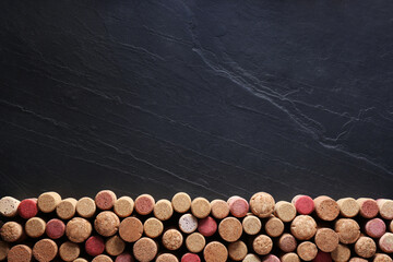 Canvas Print - Many wine bottle corks on black table, flat lay. Space for text