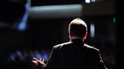 back of person giving a speech. man talking in front of audience