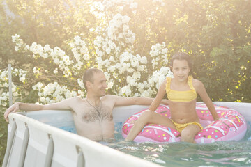 Father playing with his daughter in swimming pool