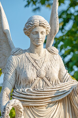 Wall Mural - Statue of ancient beautiful winged angel in downtown city park of Potsdam at sunset, Germany, portrait, details.