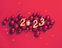 Date 2023 Red Background Of Christmas Toys, Balls Sparkles. Beautiful Festive New Year's Mockup