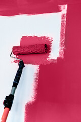 Painting and refreshing the wall with viva magenta color paint using roller, color of the year 2023