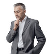 © stokkete - Businessman thinking with hand on chin