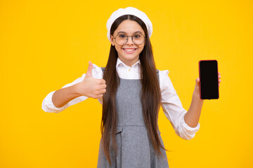 Sticker - Teenager child girl holding smartphone. Hipster girl with cell phone. Kid hold mobile phone texting in online social networks. Kid showing blank screen mobile phone, mock up copy space.