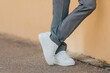 © Omar Tursić/Wirestock Creators - Close-up shot of a man wearing white sneakers with gray classic pants