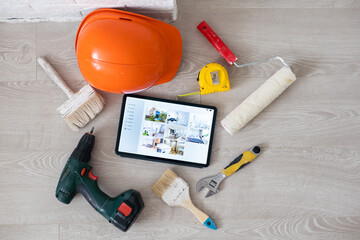 repair, diy and home improvement concept - close up of tablet pc computer and painting tools on table.