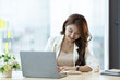 © Wasan - Charming Asian businesswoman working on a laptop in the office.
