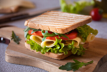 Wall Mural - Delicious sandwich with toasted bread, lettuce, cheese and tomatoes. Healthy homemade snack