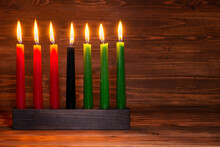 Kwanzaa Festival Concept With Seven Candles Red, Black And Green In Candlestick On Wooden Background, Copy Space
