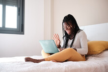Happy Woman Waving Hand To Video Friend Using Netbook In Bedroom