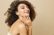 © SHOTPRIME STUDIO - Woman beauty face close-up applying anti-aging moisturizer with fingers of her hand, skin health nails and hair, hair dryer style curly afro hair, body and beauty care concept