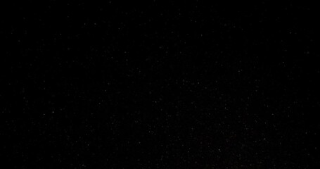 Wall Mural - Cinematic dust particles floating on black background in slow motion. Atmosphere overlay. Filmed with RED camera. High quality 4k footage