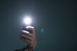 © Mihail - hand holding a smartphone used as a torched, flashlight of mobile phone in the dark