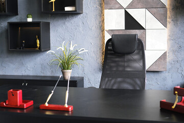 Manager's office setting. A black armchair next to a black desk.