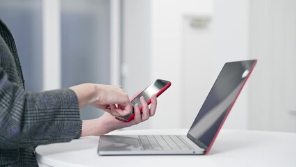 Aufkleber - Woman using smartphone and laptop in office. smartphone authentication. biometric authentication. Security.