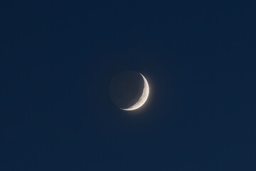 Wall Mural - Early evening, crater of moon on the border of light and dark, planetshine phenomenon