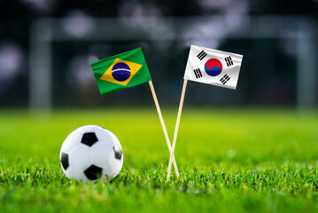Wall Mural - Brazil - South Korea Eight final, Last 16 football match. Round of 16. Handmade national flags and soccer ball on green grass. Football stadium in background. Black edit space.