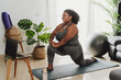 © Alessandro Biascioli - Young African woman taking Pilates fitness class with laptop at home - Sport wellness people lifestyle concept