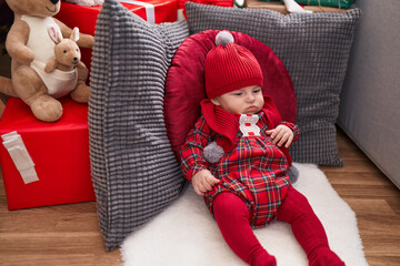 Sticker - Adorable caucasian baby sitting on floor by christmas gifts at home