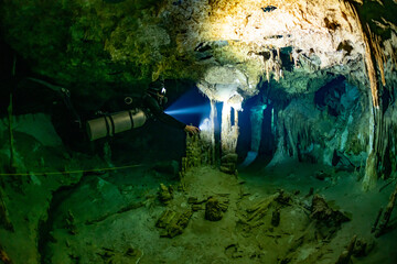 Wall Mural - cave diver instructor leading a group of divers in a mexican cenote underwater