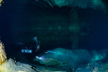 Wall Mural - cave diver instructor leading a group of divers in a mexican cenote underwater