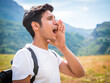 © theartofphoto - Male hiker calling in mountains with hand at mouth