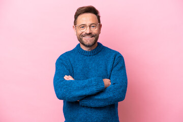 Wall Mural - Middle age caucasian man isolated on pink background keeping the arms crossed in frontal position