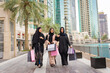 © oneinchpunch - Arabic women wearing traditional middle eastern abaya clothing in Dubai, shopping and having fun outdoors