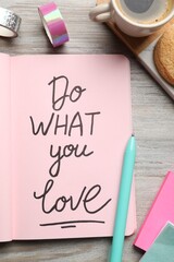 Wall Mural - Open notebook with motivational phrase Do What You Love on wooden table, flat lay