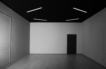 Canvas Print - Empty renovated room with white walls and black door