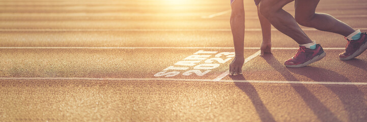 Side view of a man preparing to run on an athletics track. Engraved year 2023 symbolizing the beginning of the new year. Achievement goals get ready for the new year.copy space