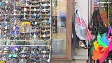 HUSTOPECE, CZECHIA - NOVEMBER 26, 2022: Display rack with sunglasses in front of a small general shop. Retail rack with various sunglasses in front of a variety store. The boxes with artificial