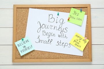 Wall Mural - Corkboard with motivational quotes on white wooden table, top view