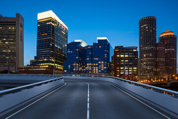 Empty urban asphalt road exterior with city buildings background. New modern highway concrete construction. Concept of way to success. Transportation logistic industry fast delivery. Boston. USA.